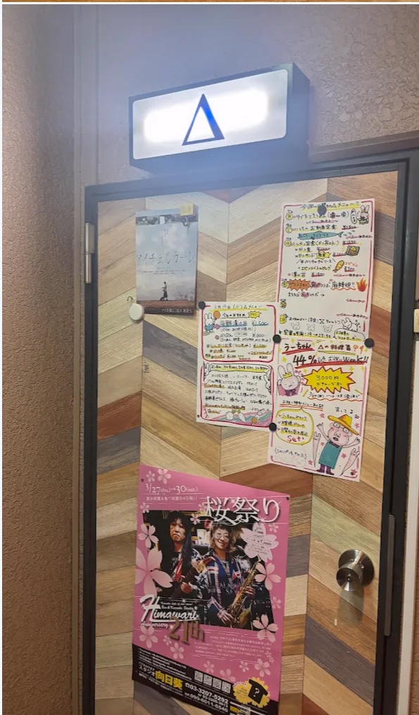 The entrance door with a lit Δ sign above it