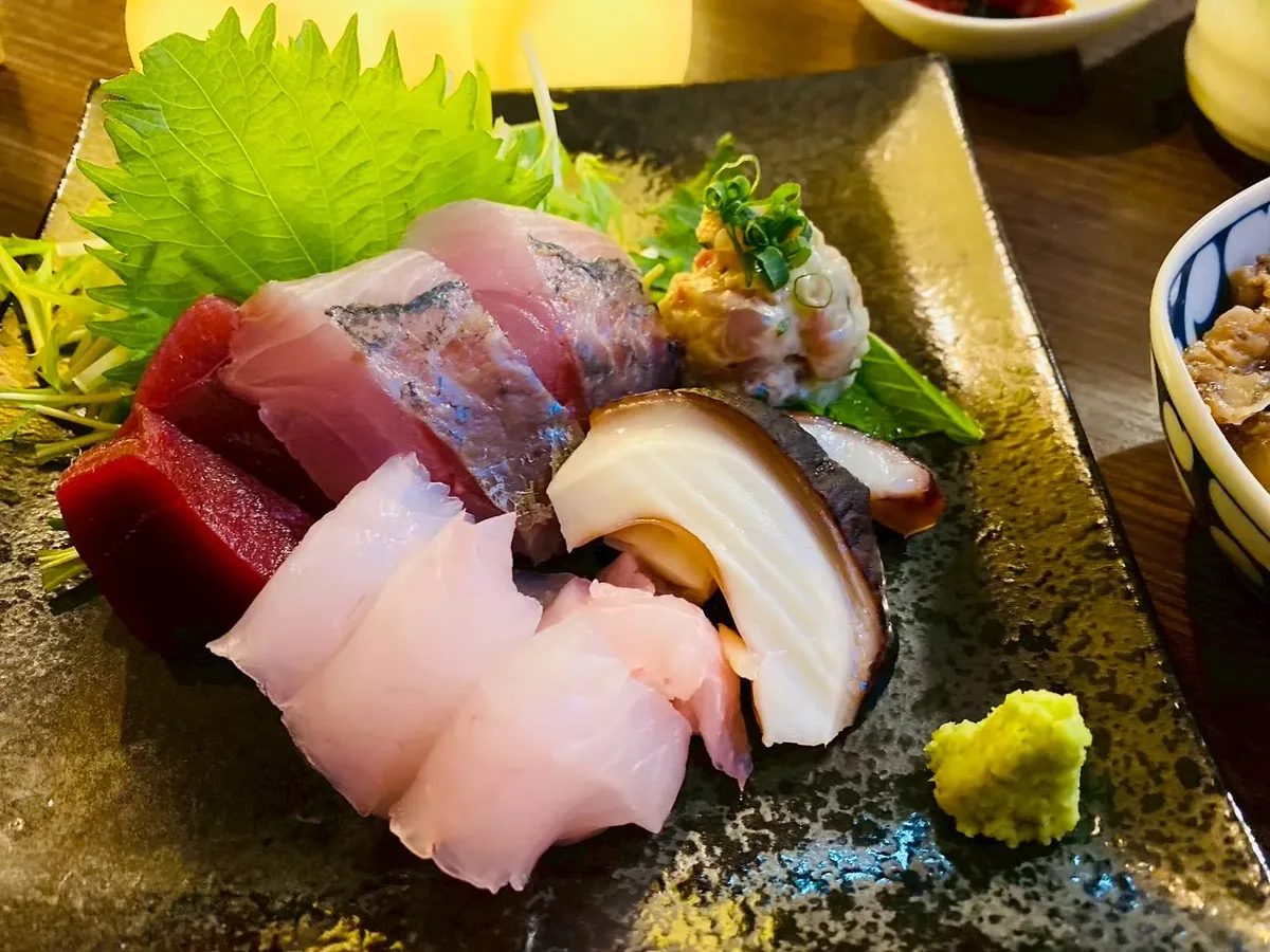 An assortment of sashimi on a dark plate